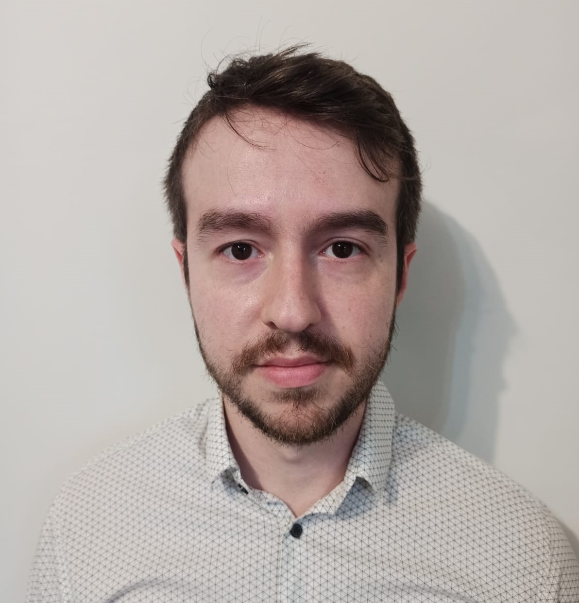 O autor, Fernando Pablos, está usando camisa social, seu cabelo é curto, de cor castanha e barba curta.